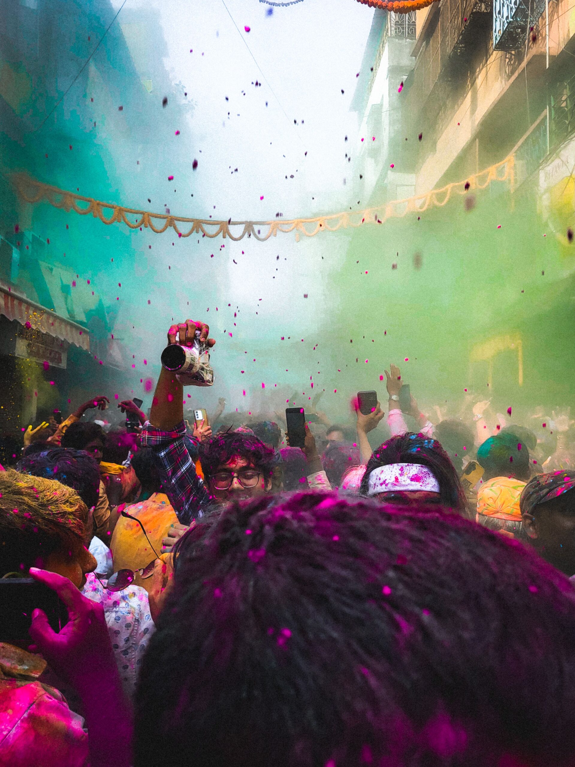 Colorful Holi festival celebration with vibrant powders in a crowded street scene.